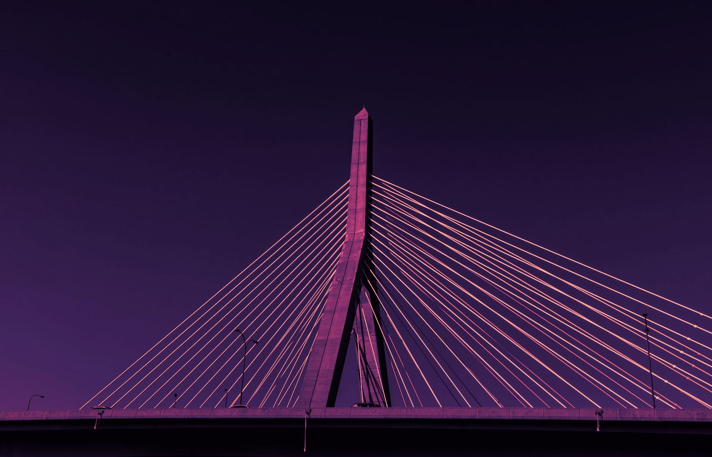 The Zakim bridge at night, its cables fanning out from a single mast